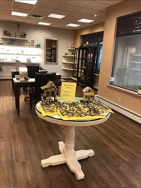 The image shows an interior space that appears to be a store or boutique, with a display table featuring items for sale and a sign indicating Sale Items, set against the backdrop of a retail environment with shelves and merchandise.