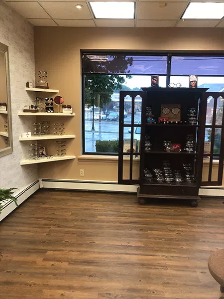 An interior view of a store with wooden flooring, display cases, and a large window.